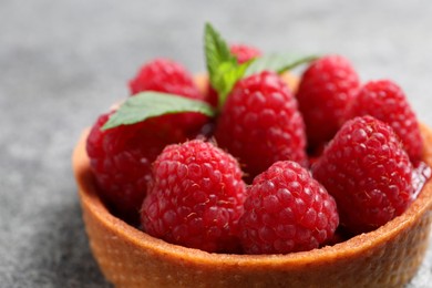 Photo of Tartlet with fresh raspberries on light grey background, closeup. Delicious dessert