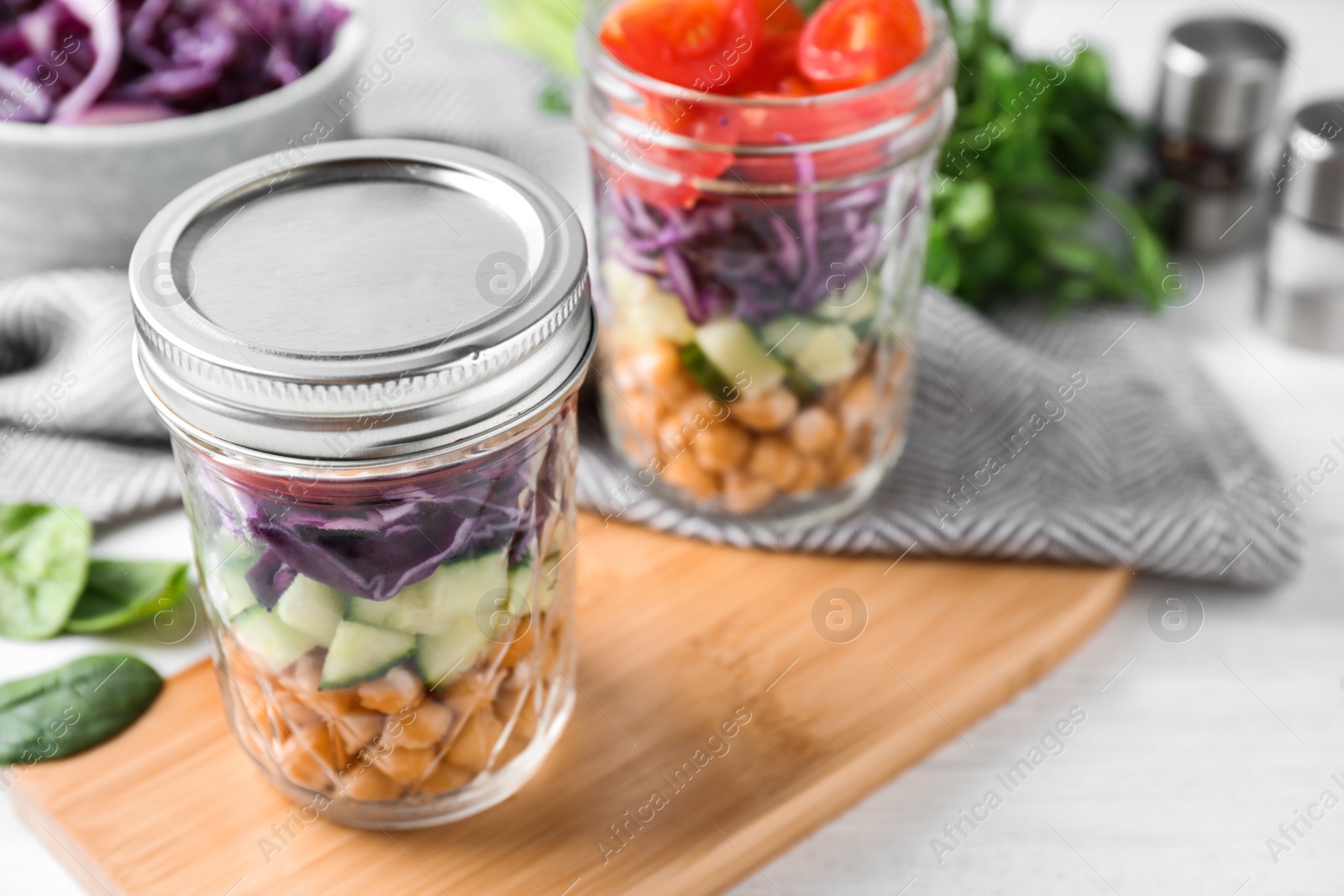 Photo of Healthy salad in glass jars on white table