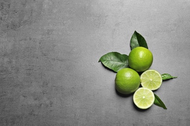 Photo of Fresh ripe limes on gray  background, top view