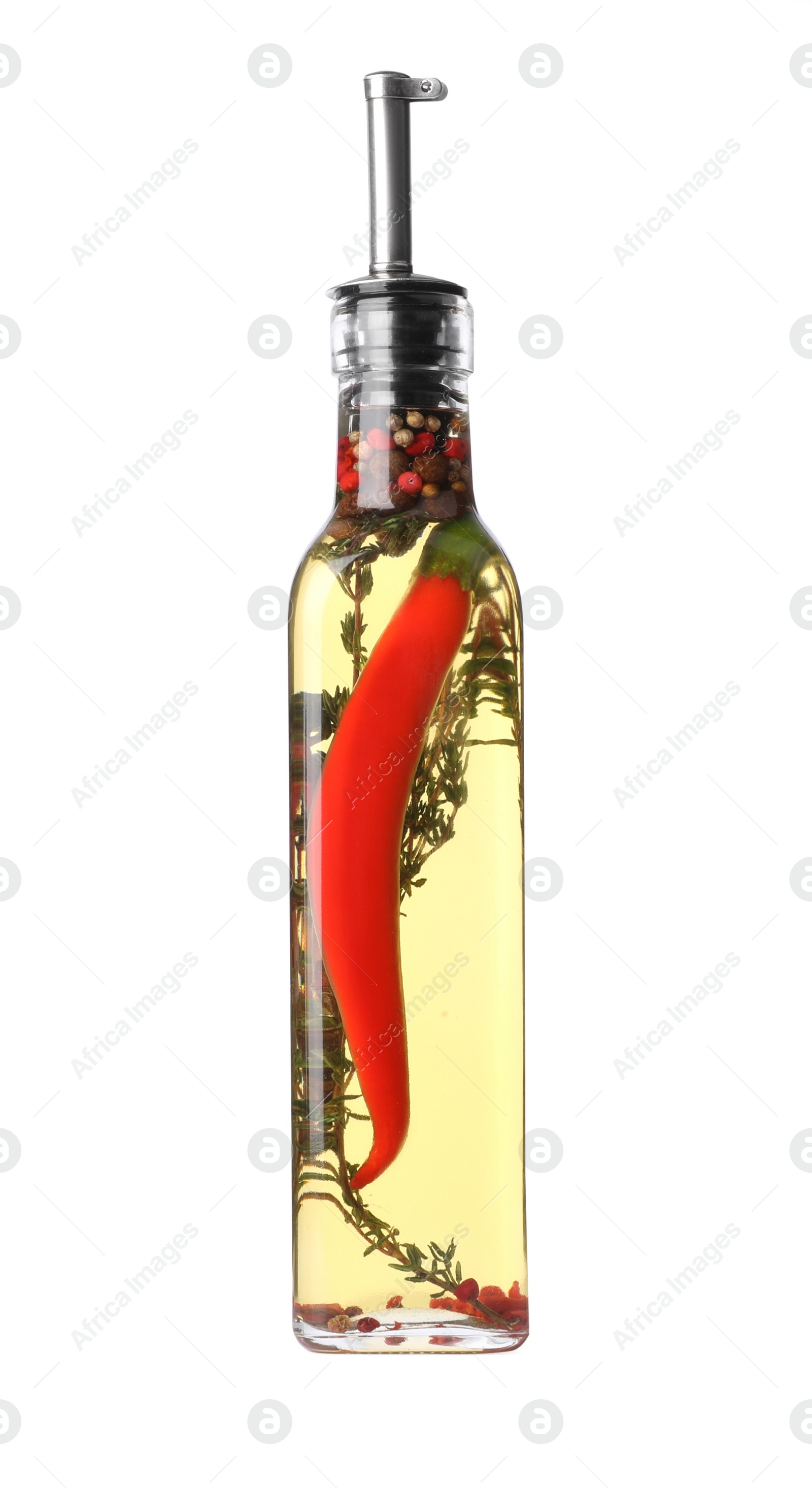 Photo of Glass bottle of cooking oil with spices and herbs isolated on white