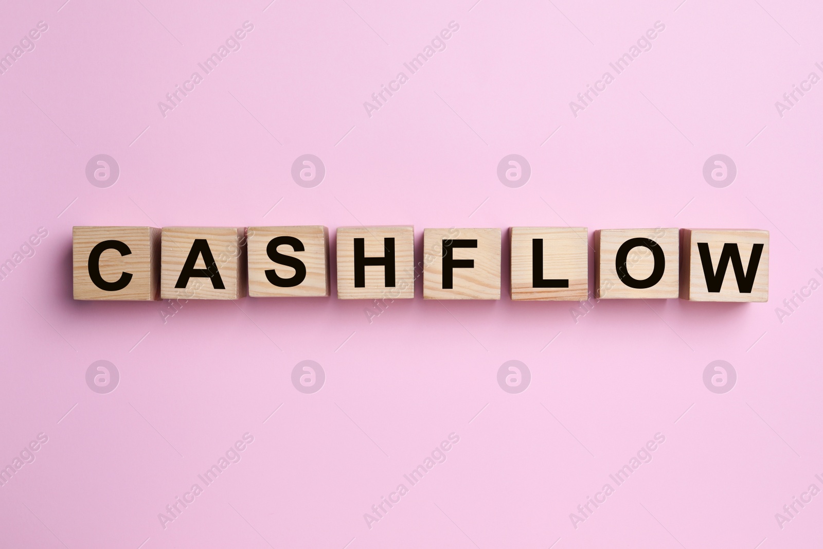 Image of Wooden cubes with phrase Cash FLow on pink background, flat lay