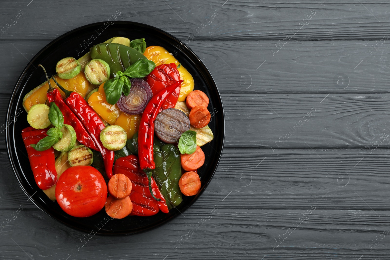 Photo of Delicious grilled vegetables on grey wooden table, top view. Space for text