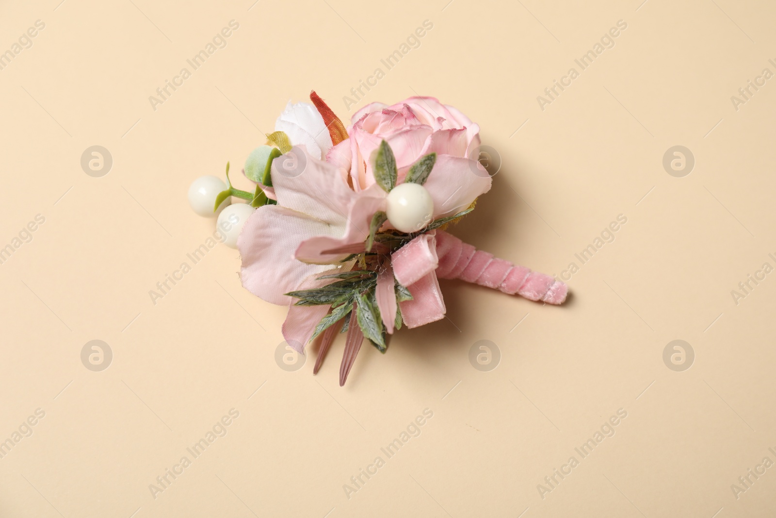 Photo of Stylish pink boutonniere on beige background, top view