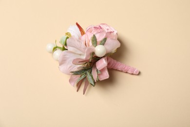 Stylish pink boutonniere on beige background, top view