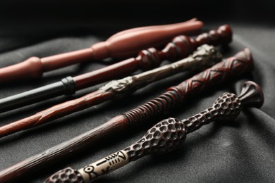 Photo of Different magic wands on black fabric, closeup view