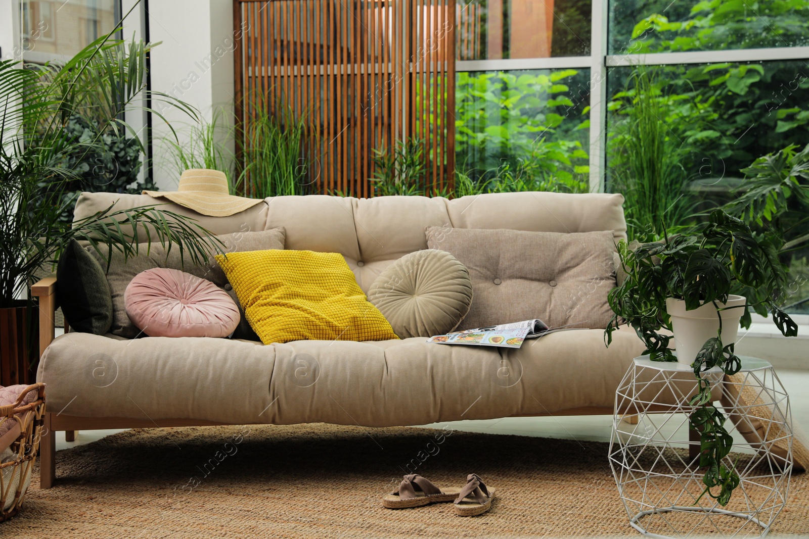 Photo of Indoor terrace interior with comfortable sofa and green plants