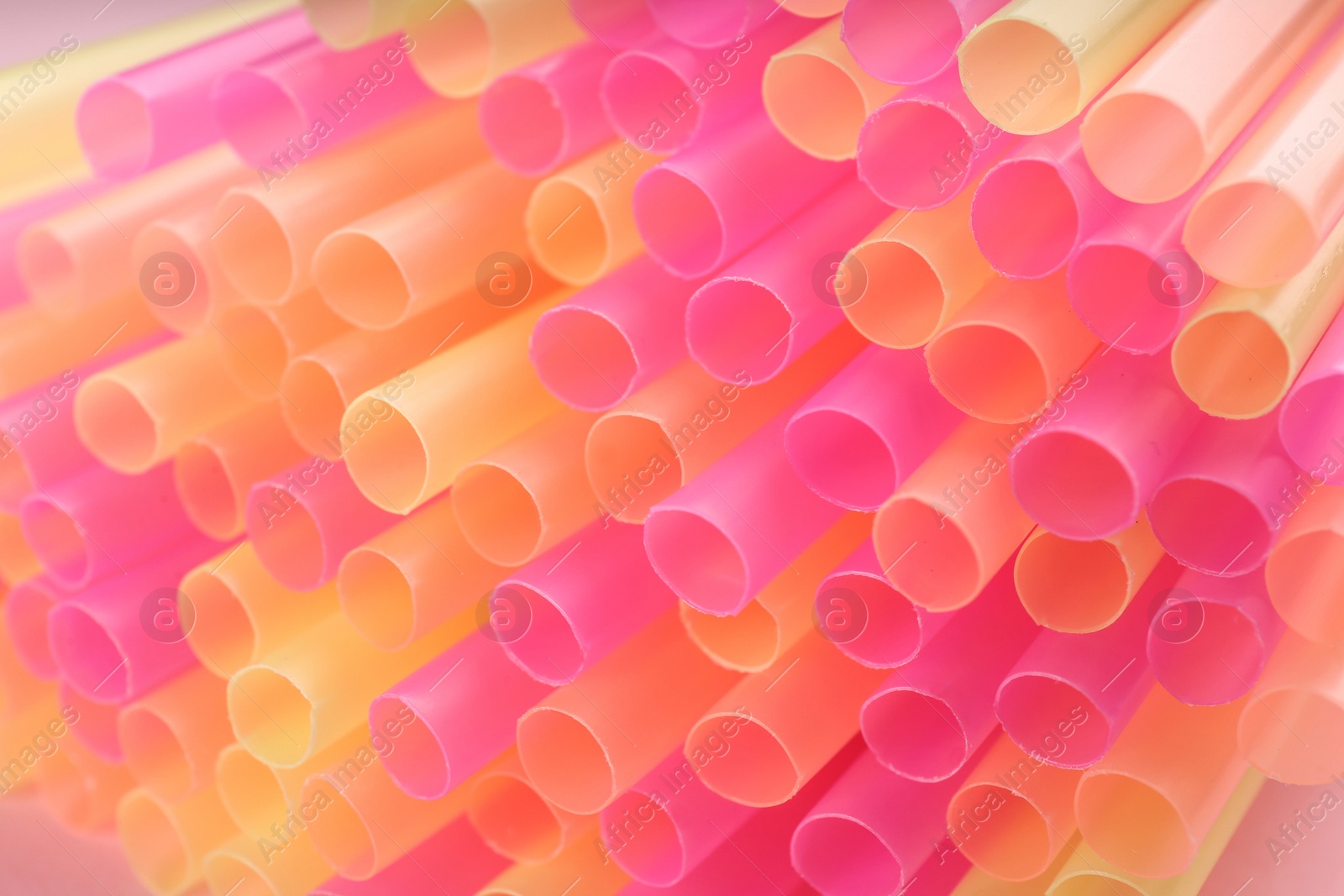 Photo of Heap of colorful plastic straws for drinks, closeup