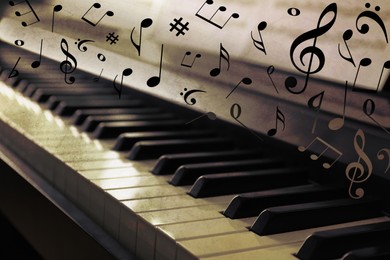 Image of Music notes and other musical symbols over piano, closeup. Vintage effect