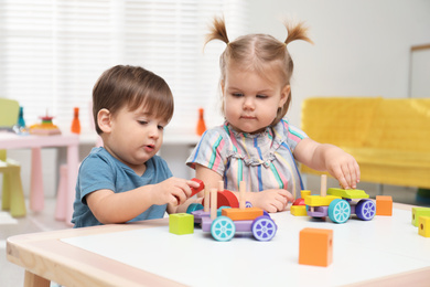 Photo of Little children playing with construction set at table