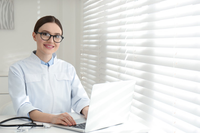 Photo of Portrait of young female doctor in white coat at workplace