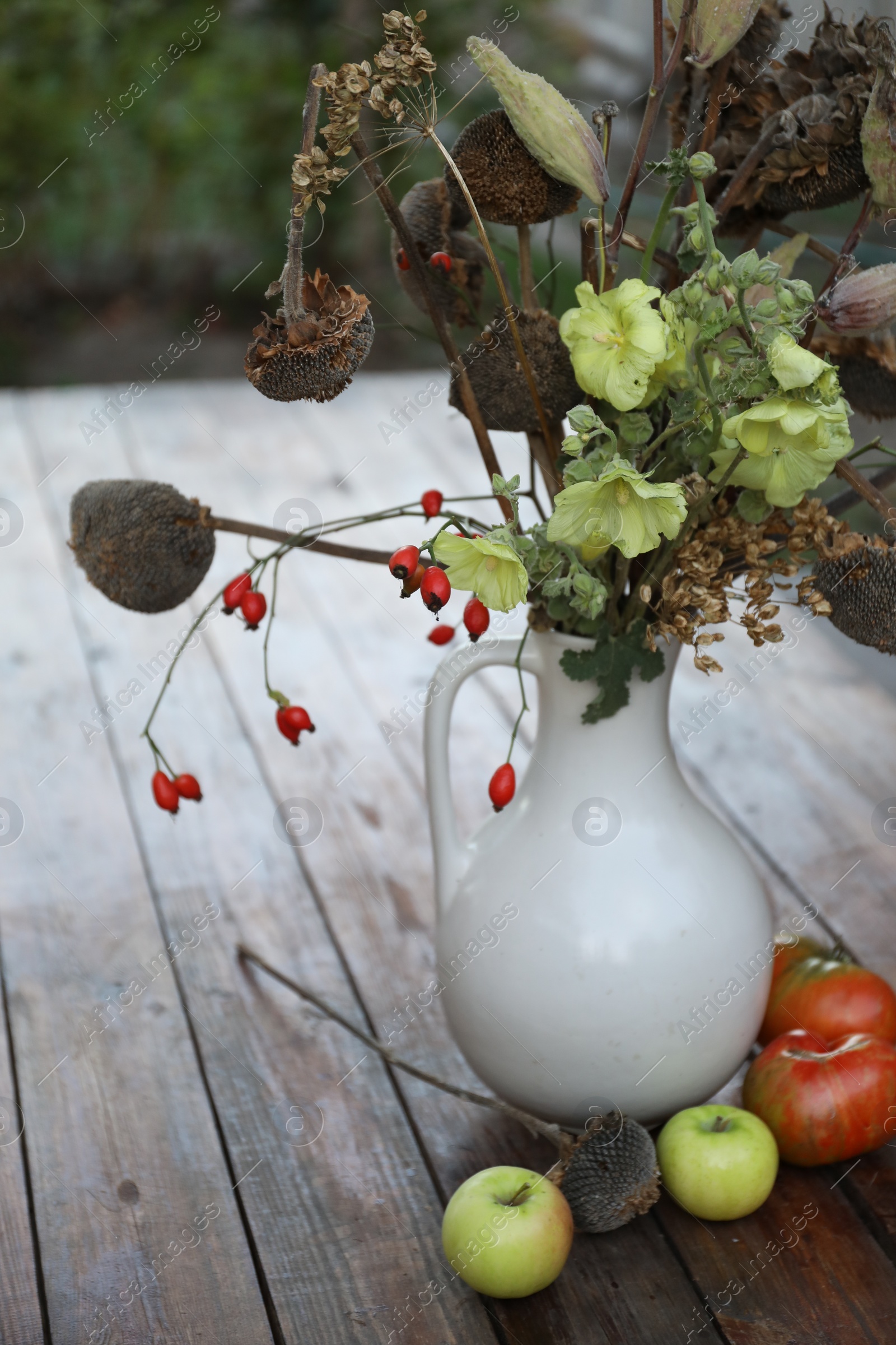 Photo of Beautiful autumn composition with different flowers on wooden table outdoors