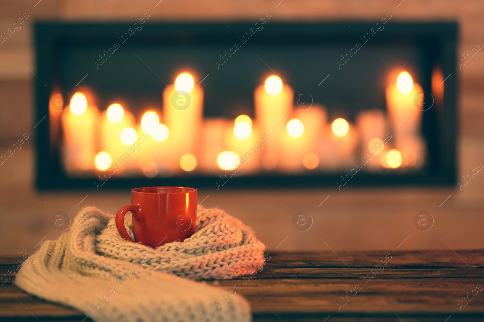 Photo of Cup of hot drink on wooden table against blurred background, space for text. Winter atmosphere