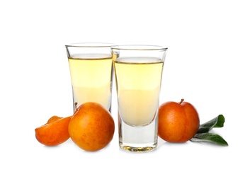 Photo of Delicious plum liquor and ripe fruits on white background. Homemade strong alcoholic beverage