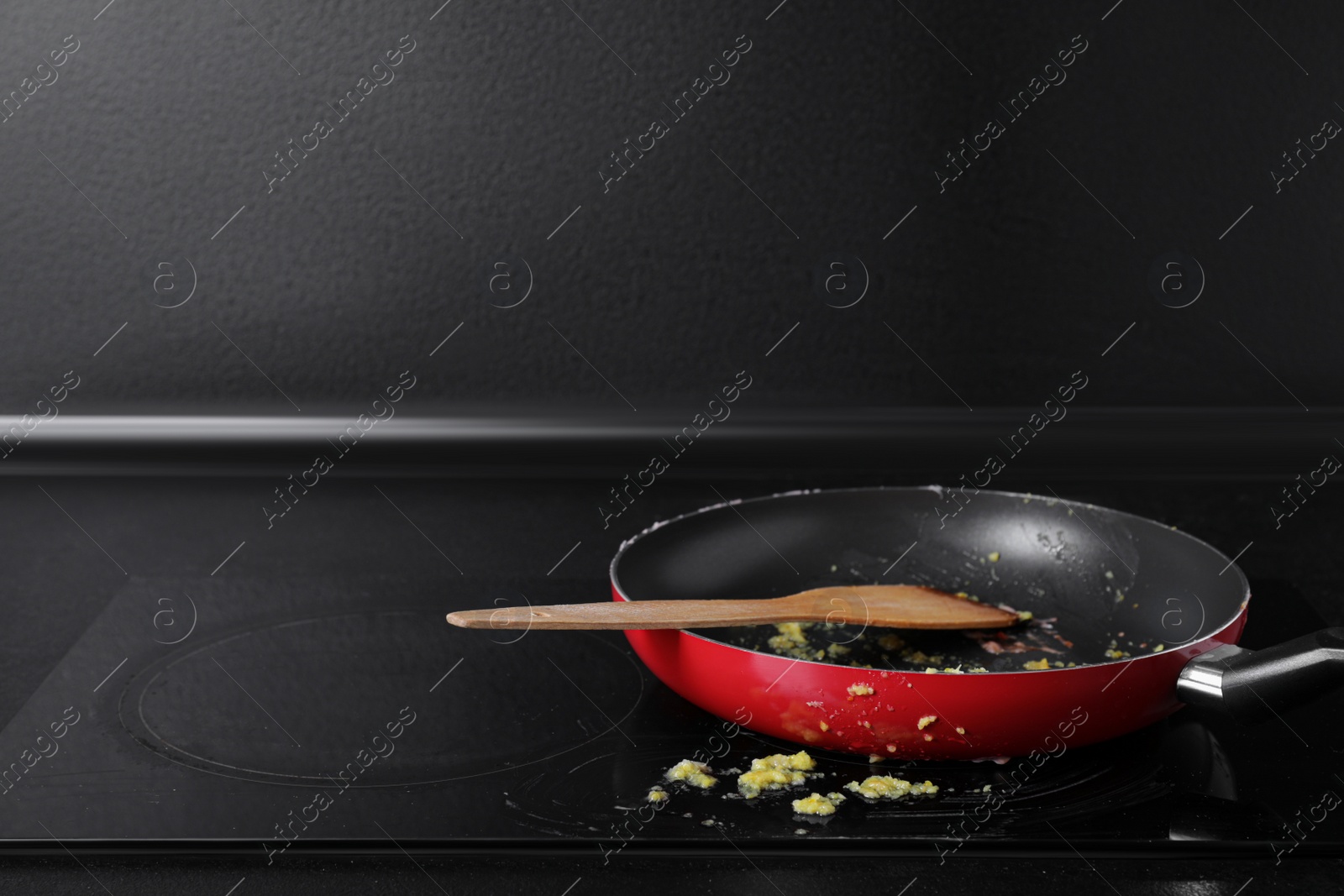 Photo of Dirty frying pan with spatula on cooktop in kitchen, space for text