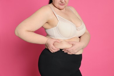 Photo of Obese woman on pink background, closeup. Weight loss surgery