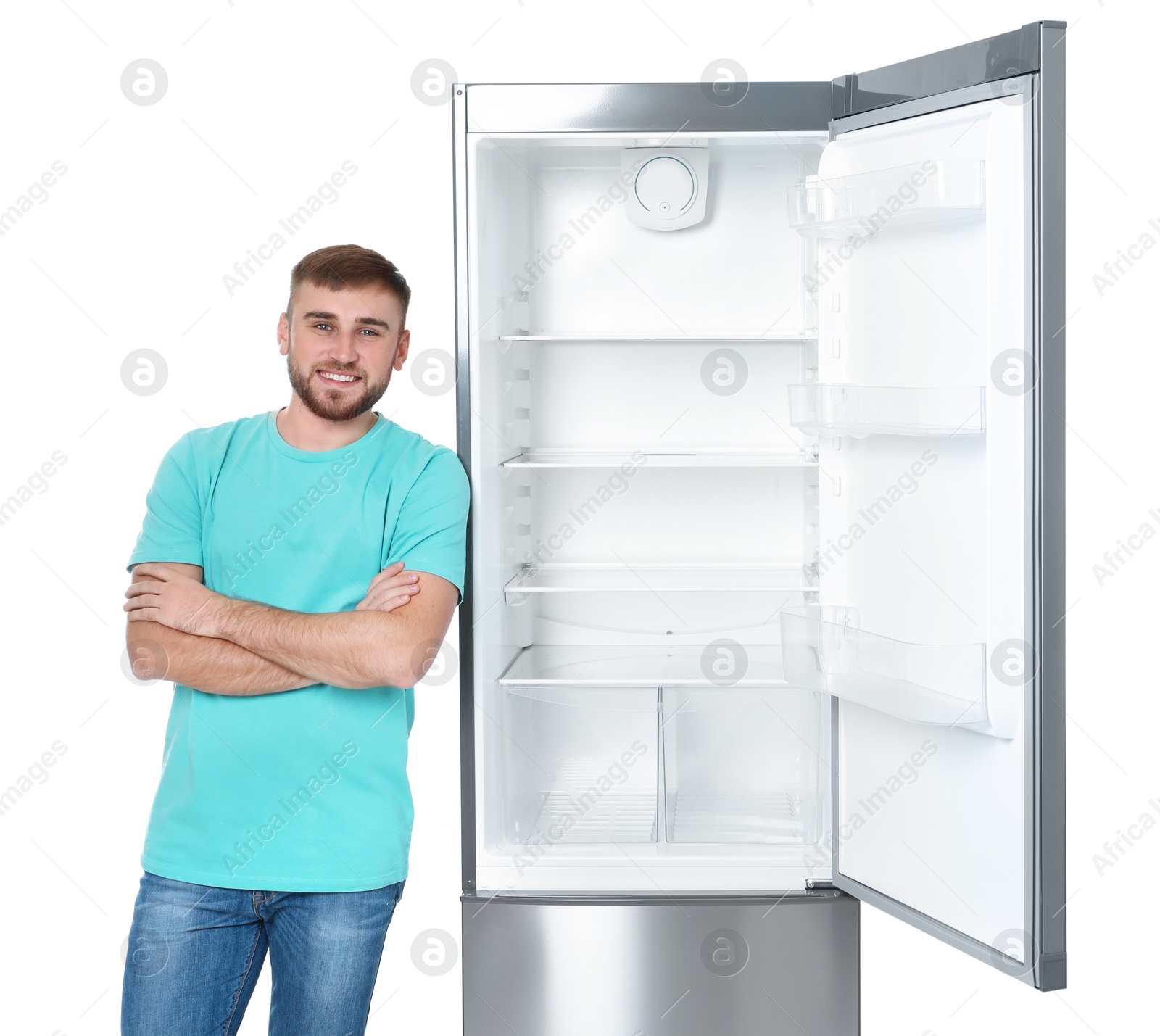 Photo of Young man near empty refrigerator on white background