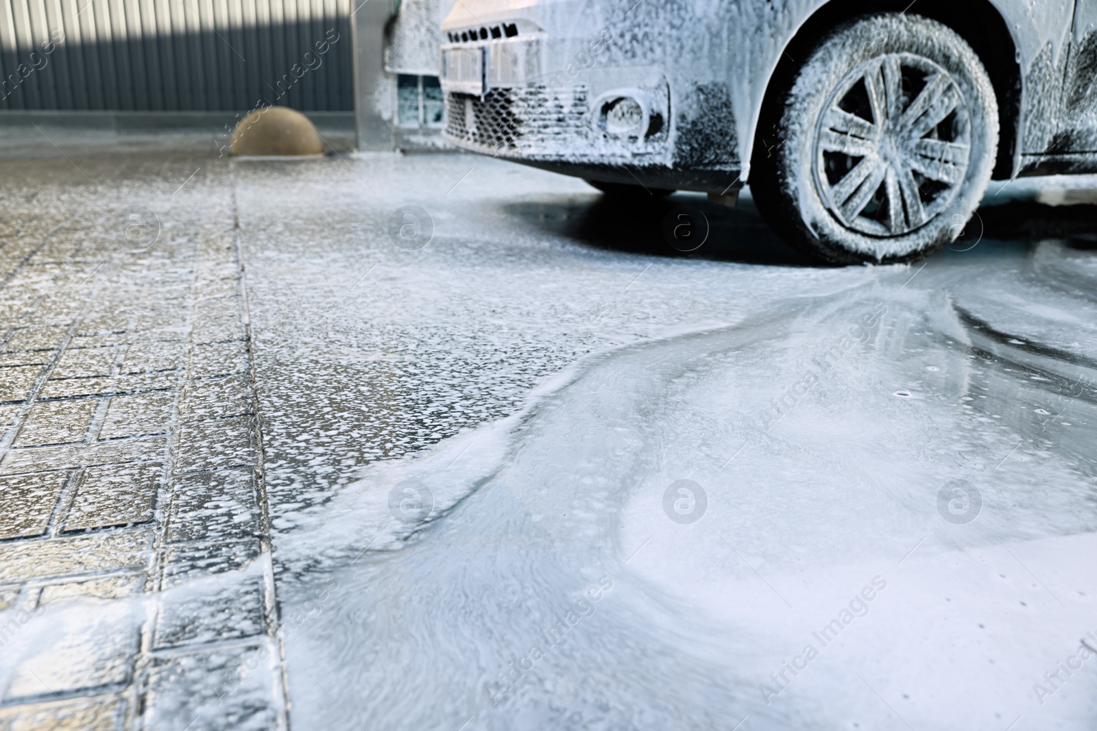 Photo of Modern automobile covered with foam at car wash