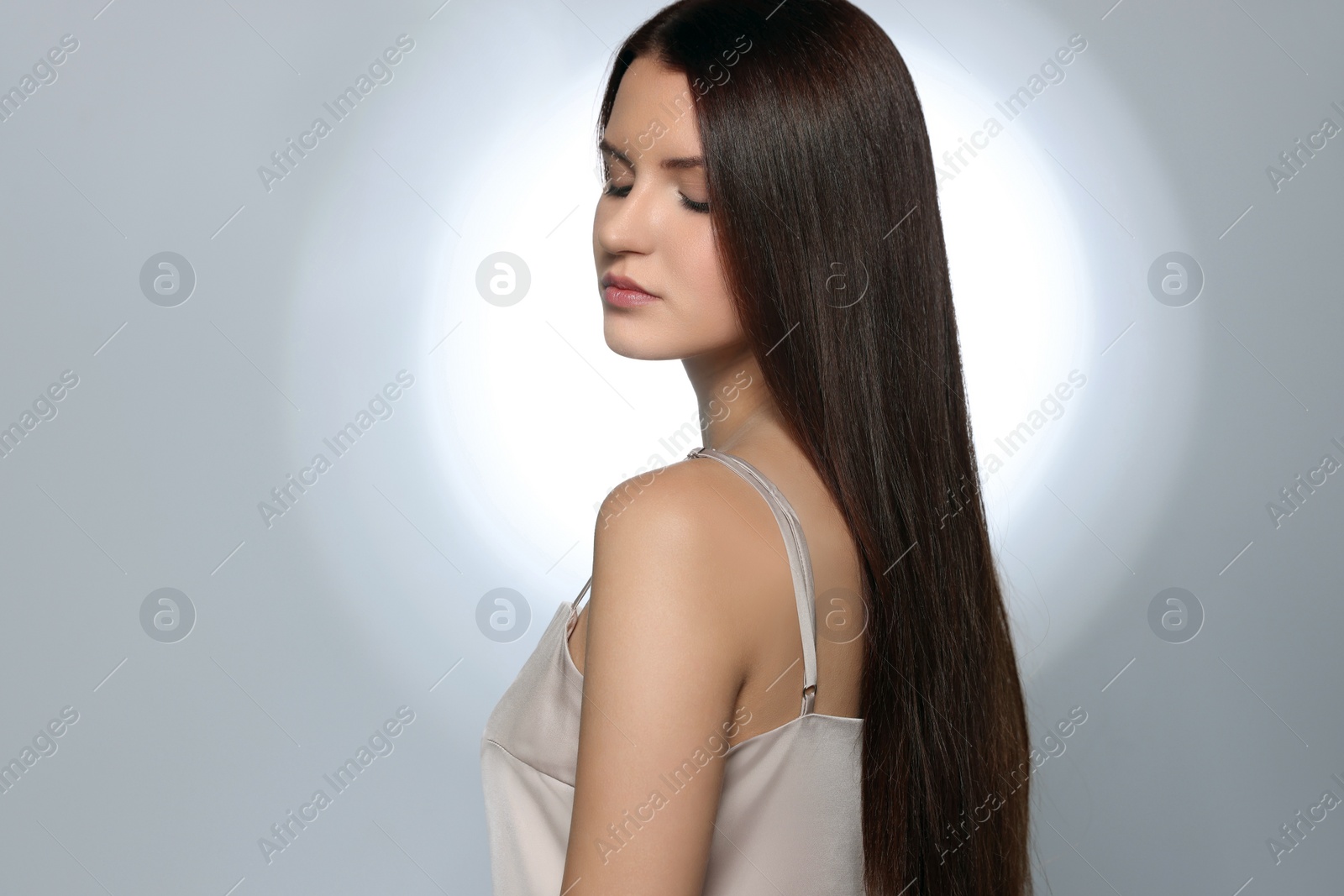 Photo of Beautiful young woman with healthy strong hair posing in studio, space for text