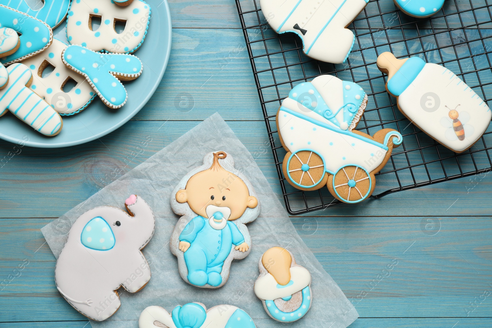 Photo of Set of baby shower cookies on turquoise wooden table, flat lay