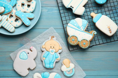 Photo of Set of baby shower cookies on turquoise wooden table, flat lay