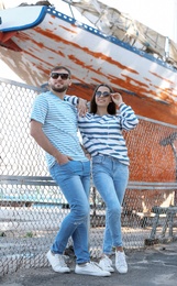 Young hipster couple in stylish jeans on pier