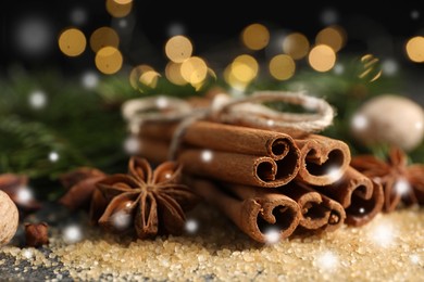 Different spices on table, closeup. Cinnamon, anise, cloves, nutmeg, brown sugar. Bokeh effect