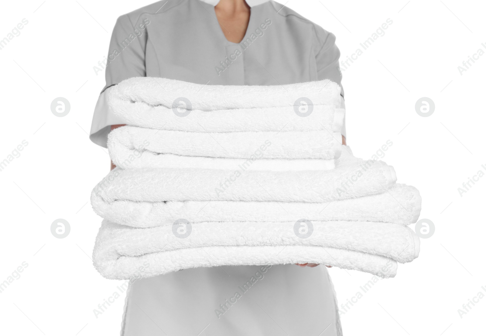 Photo of Young chambermaid with stack of clean towels on white background