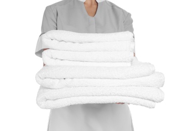 Photo of Young chambermaid with stack of clean towels on white background