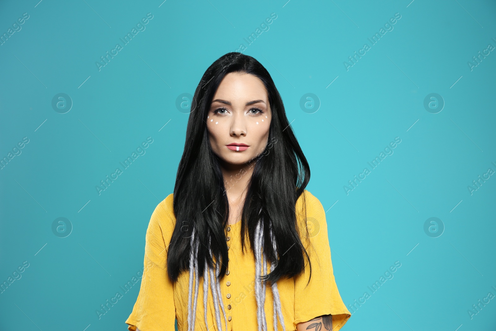 Photo of Portrait of young hippie woman with boho makeup in stylish outfit on color background