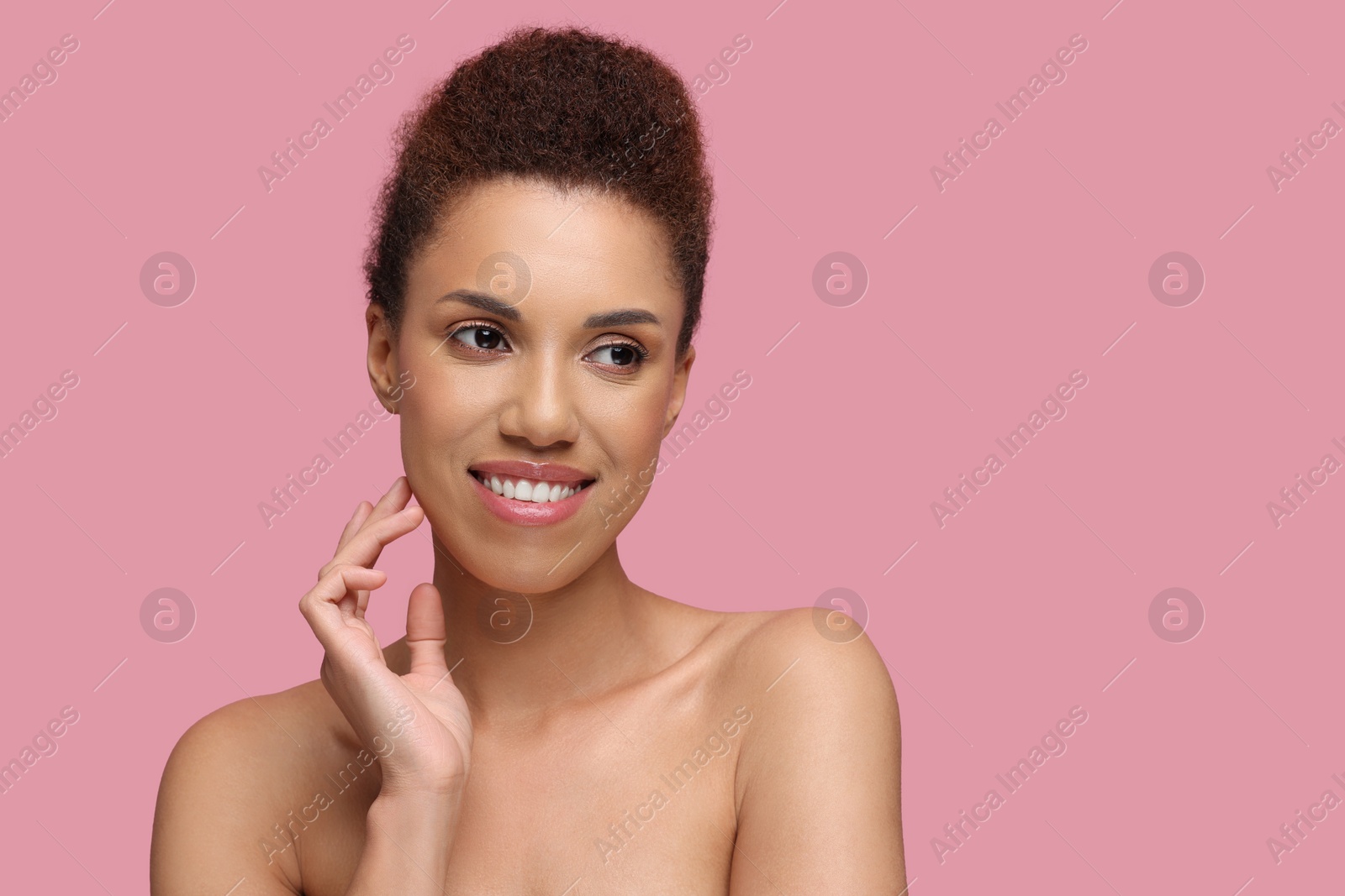 Photo of Portrait of beautiful young woman with glamorous makeup on pink background. Space for text