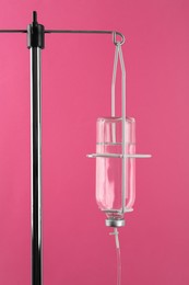 Photo of Infusion set on pink background. Intravenous therapy