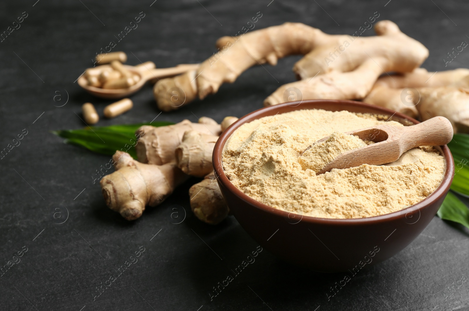 Photo of Dry and fresh ginger on black slate table, closeup