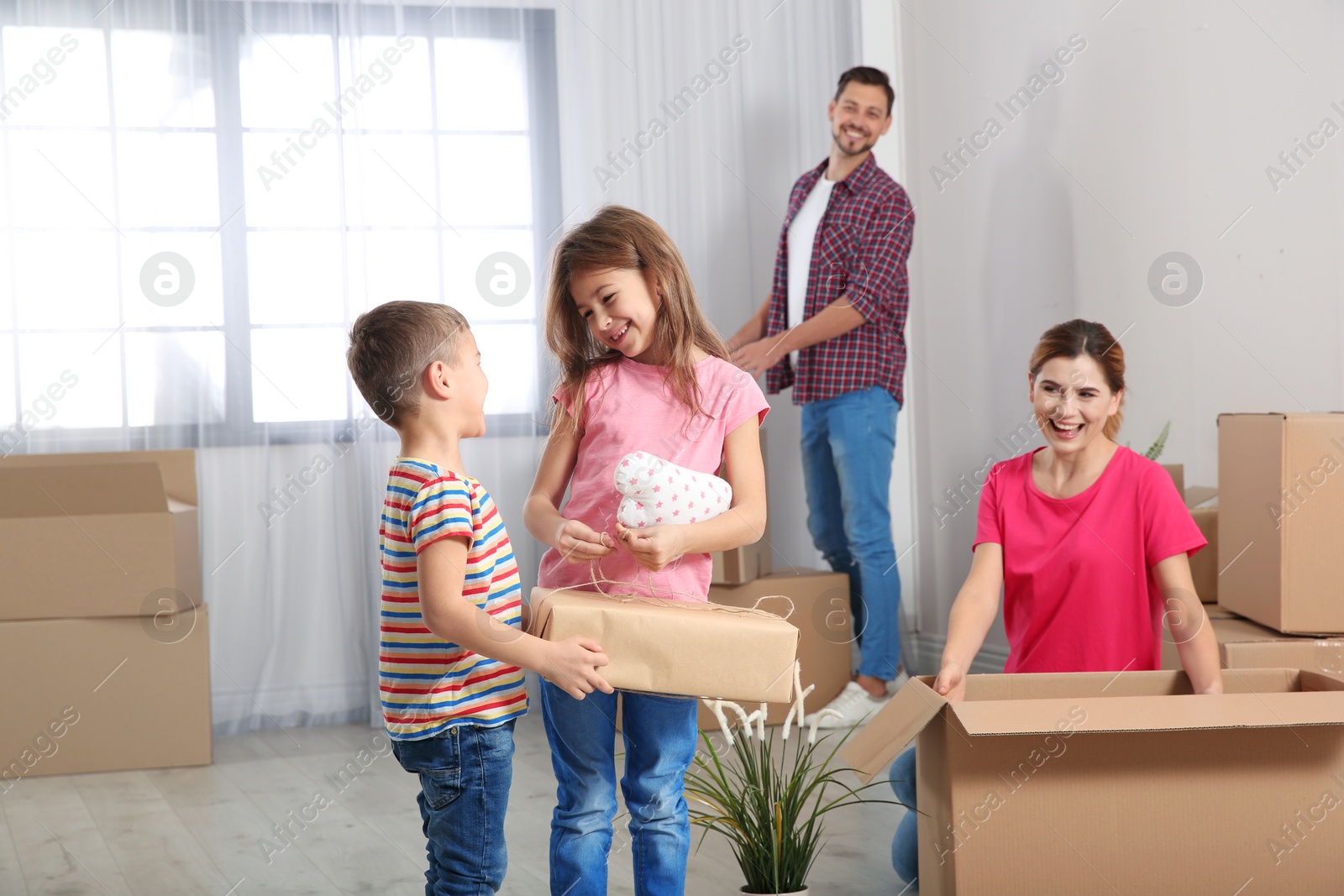 Photo of Happy family unpacking boxes in their new house. Moving day