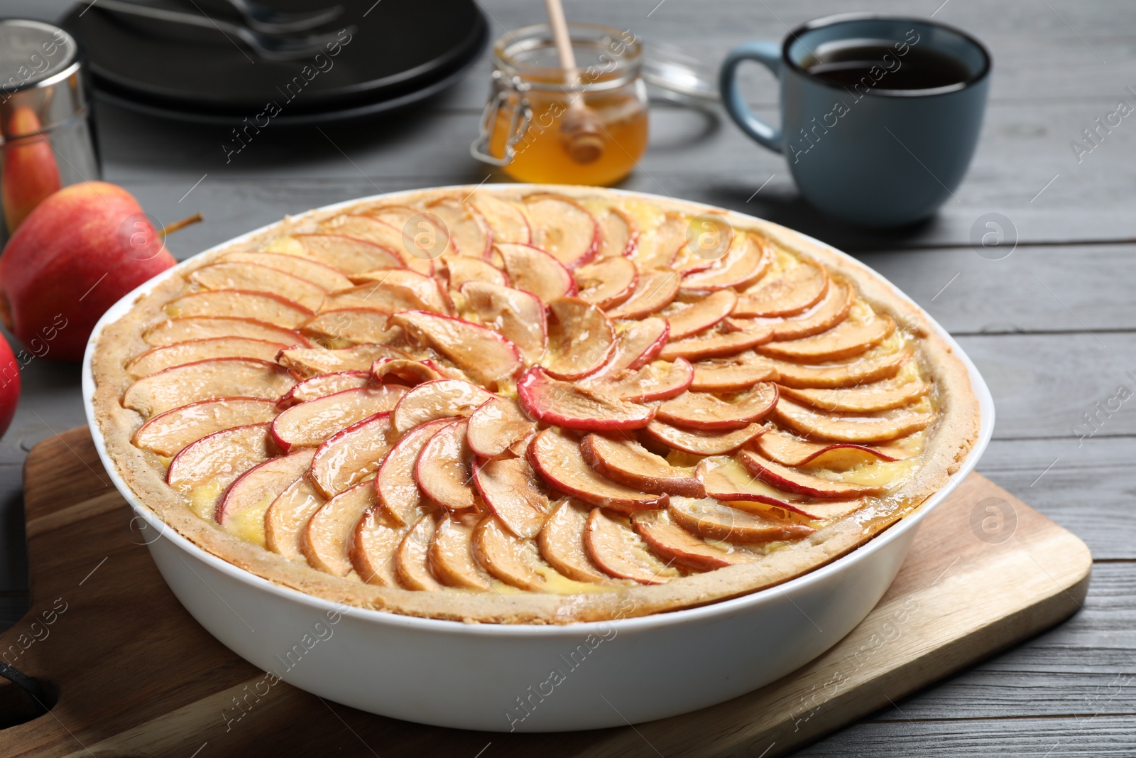Photo of Tasty apple pie on grey wooden table