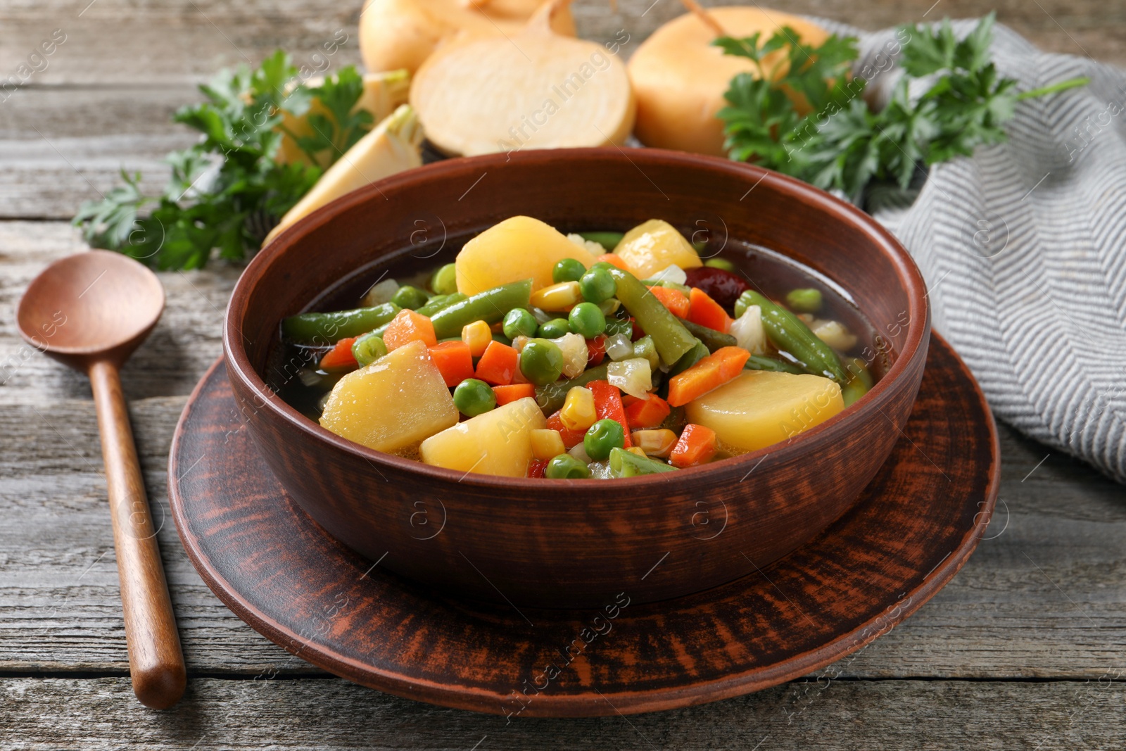 Photo of Bowl of delicious turnip soup served on wooden table