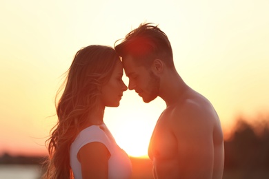 Photo of Happy young couple in beachwear outdoors at sunset