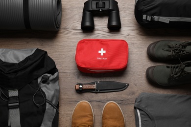 Photo of Flat lay composition with different camping equipment on wooden background