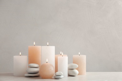 Beautiful composition with candles on table against grey background. Space for text