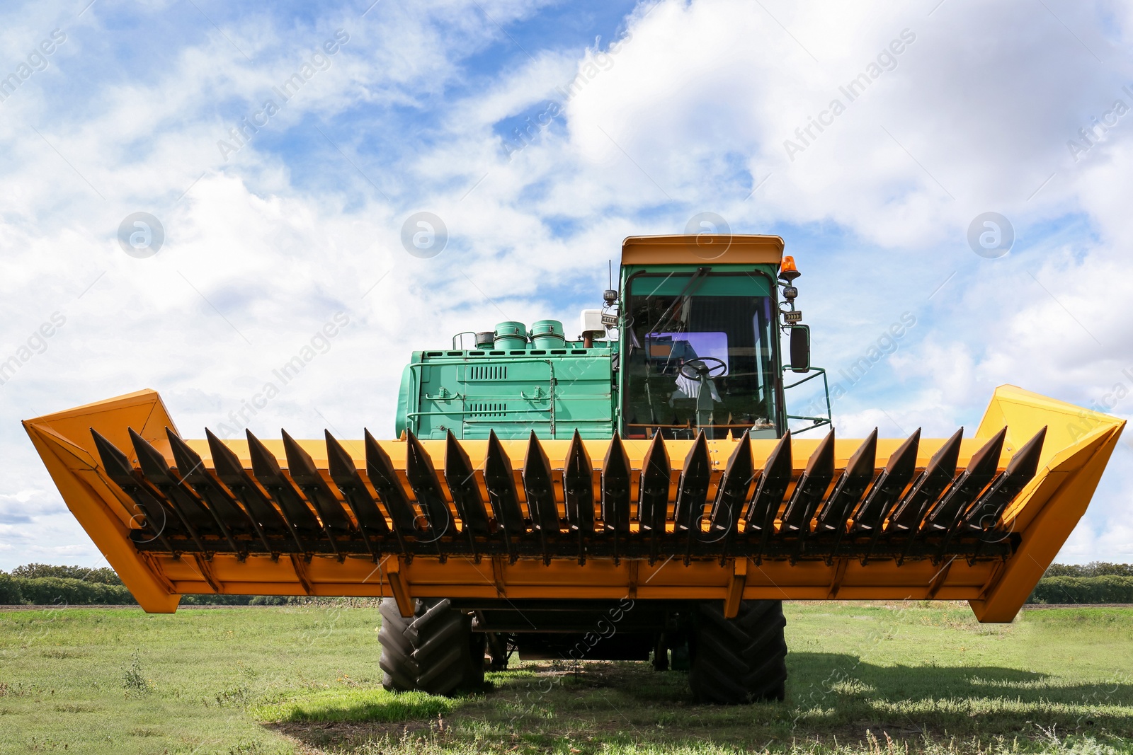 Photo of Modern combine harvester on green lawn with fresh grass