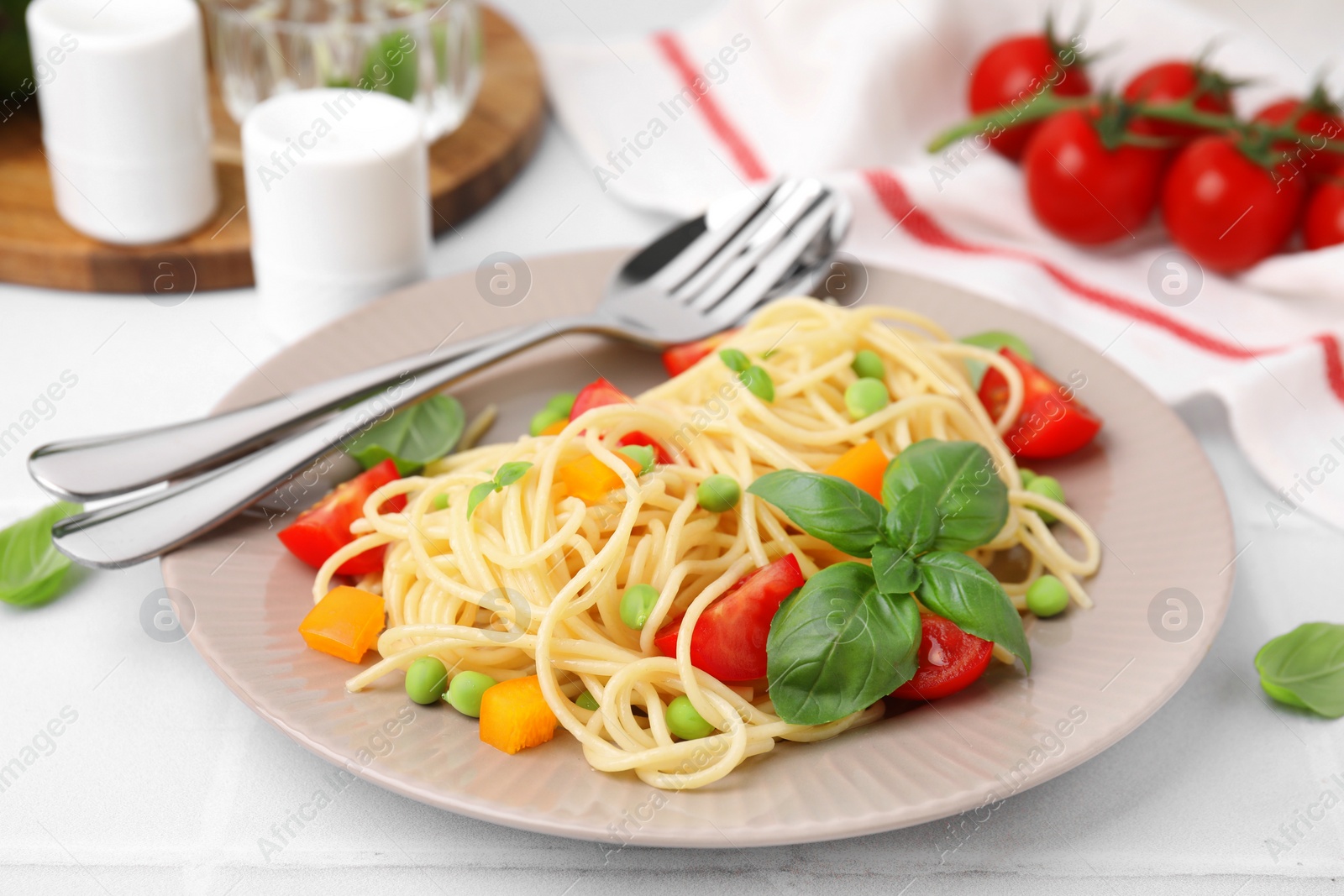 Photo of Plate of delicious pasta primavera served on white table, closeup