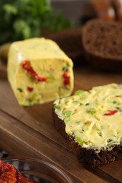 Photo of Tasty butter with green onion, chili pepper and rye bread on table, closeup