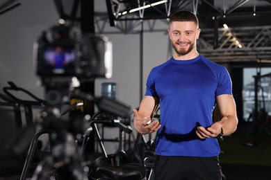 Photo of Man recording online training on camera at gym. Fitness coach