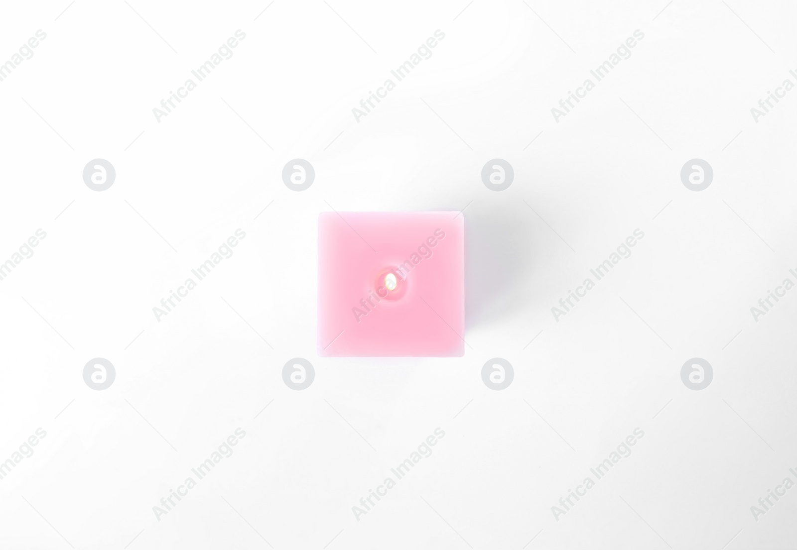 Photo of Burning pink candle isolated on white, top view