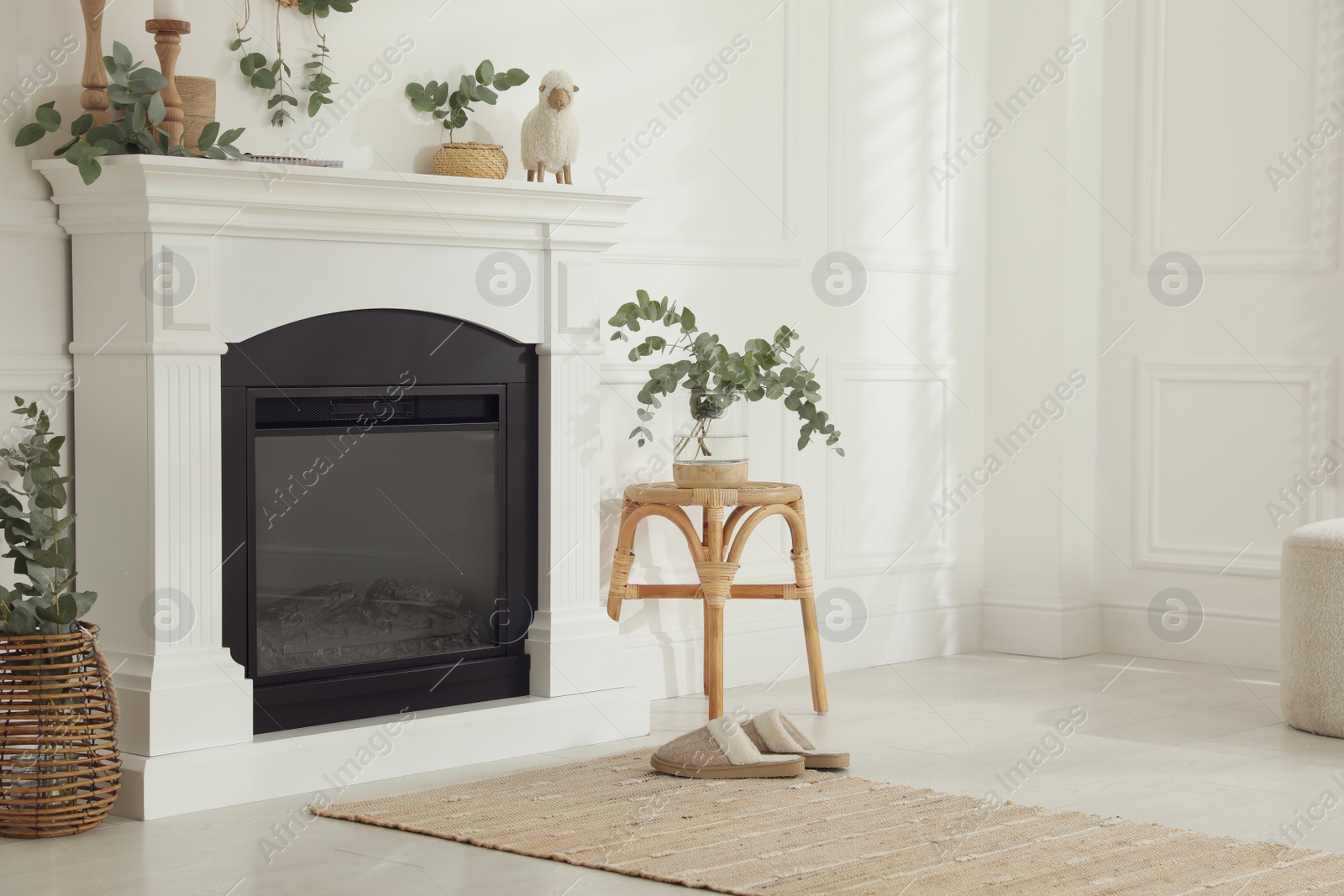 Photo of Stylish room with beautiful fireplace and eucalyptus branches