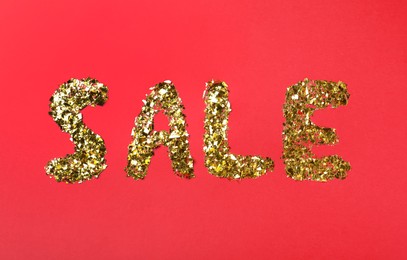 Photo of Word sale made of golden metallic confetti on red background, flat lay. Black Friday