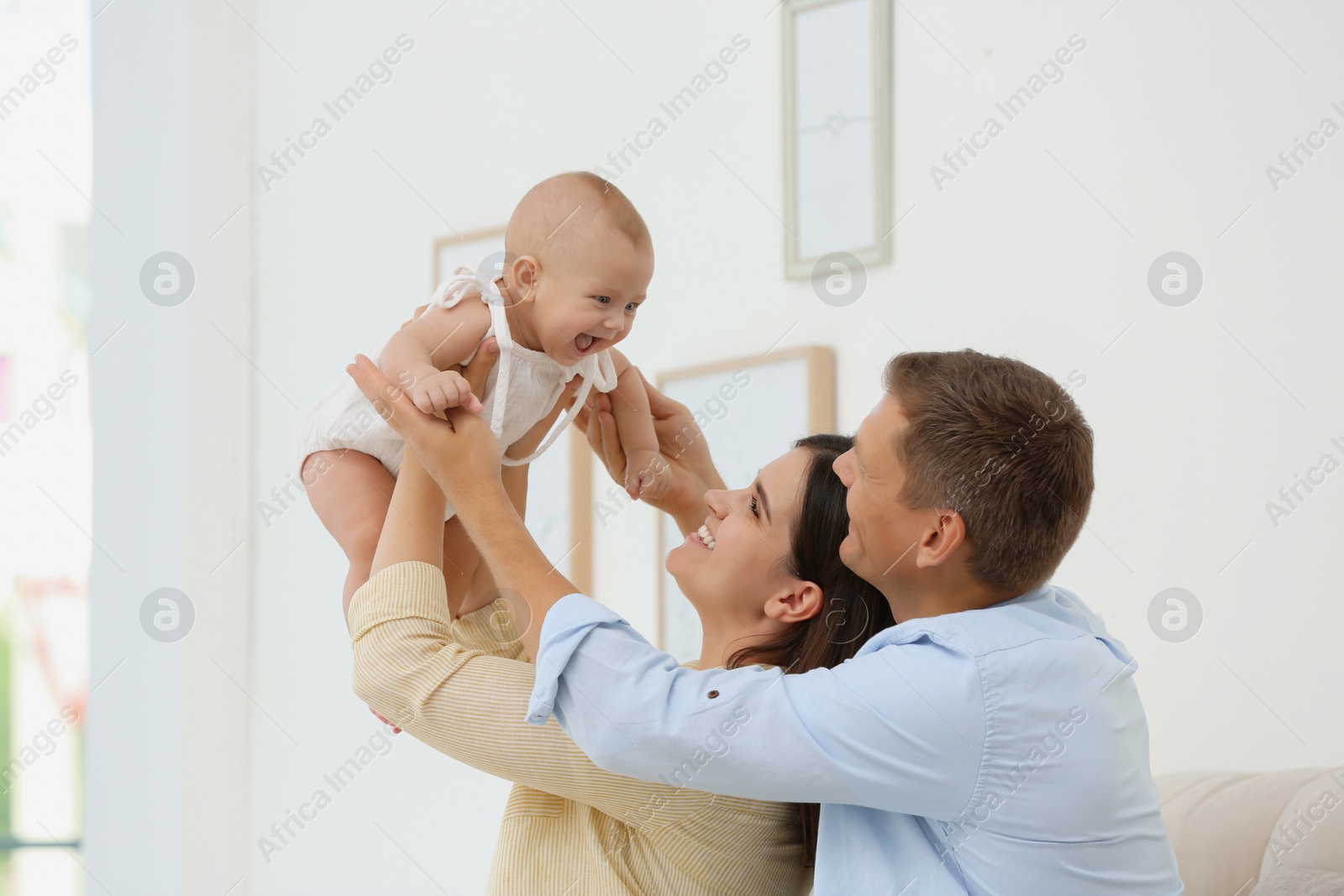 Photo of Portrait of happy family with their cute baby at home