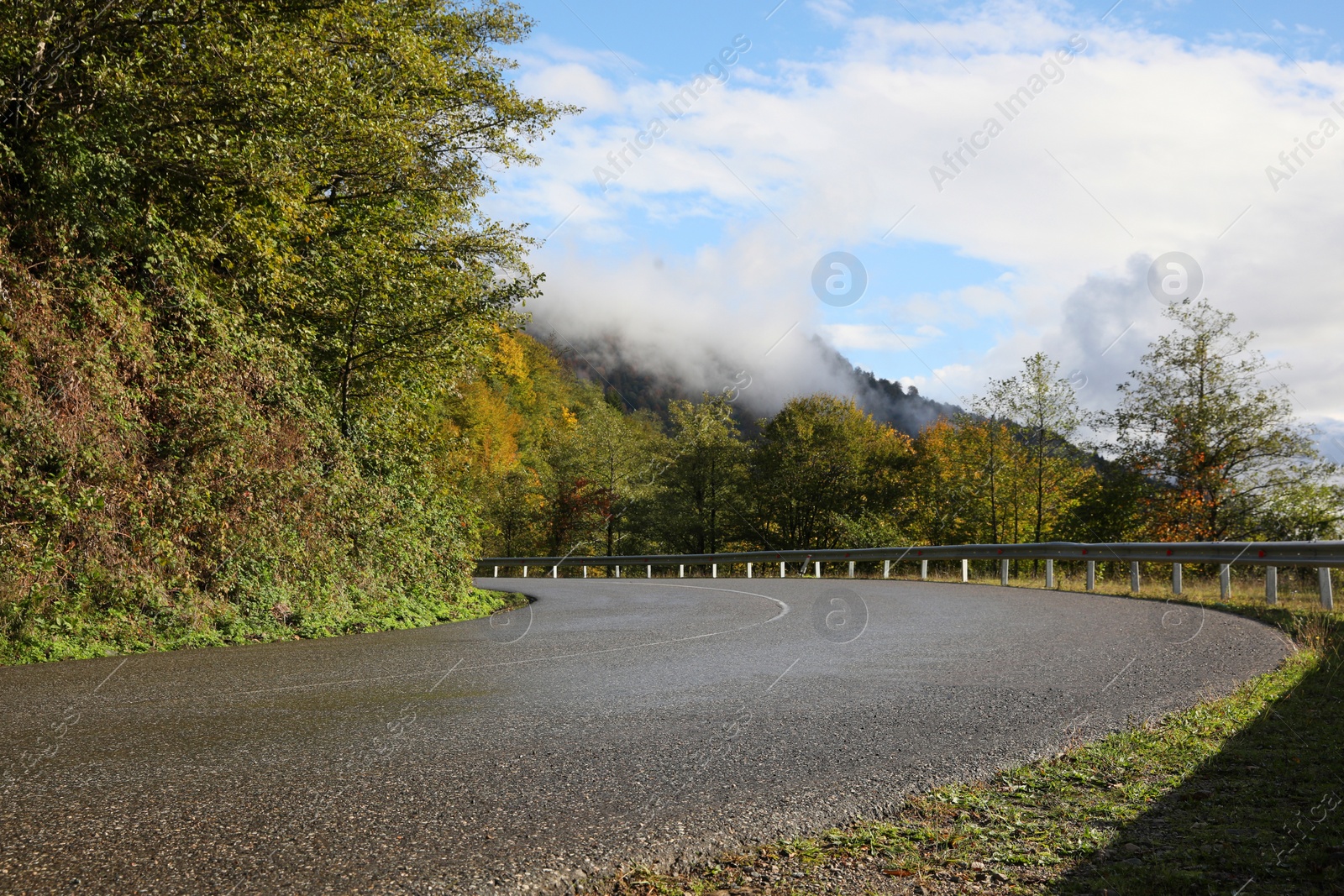 Photo of Picturesque view of empty road near trees in mountains