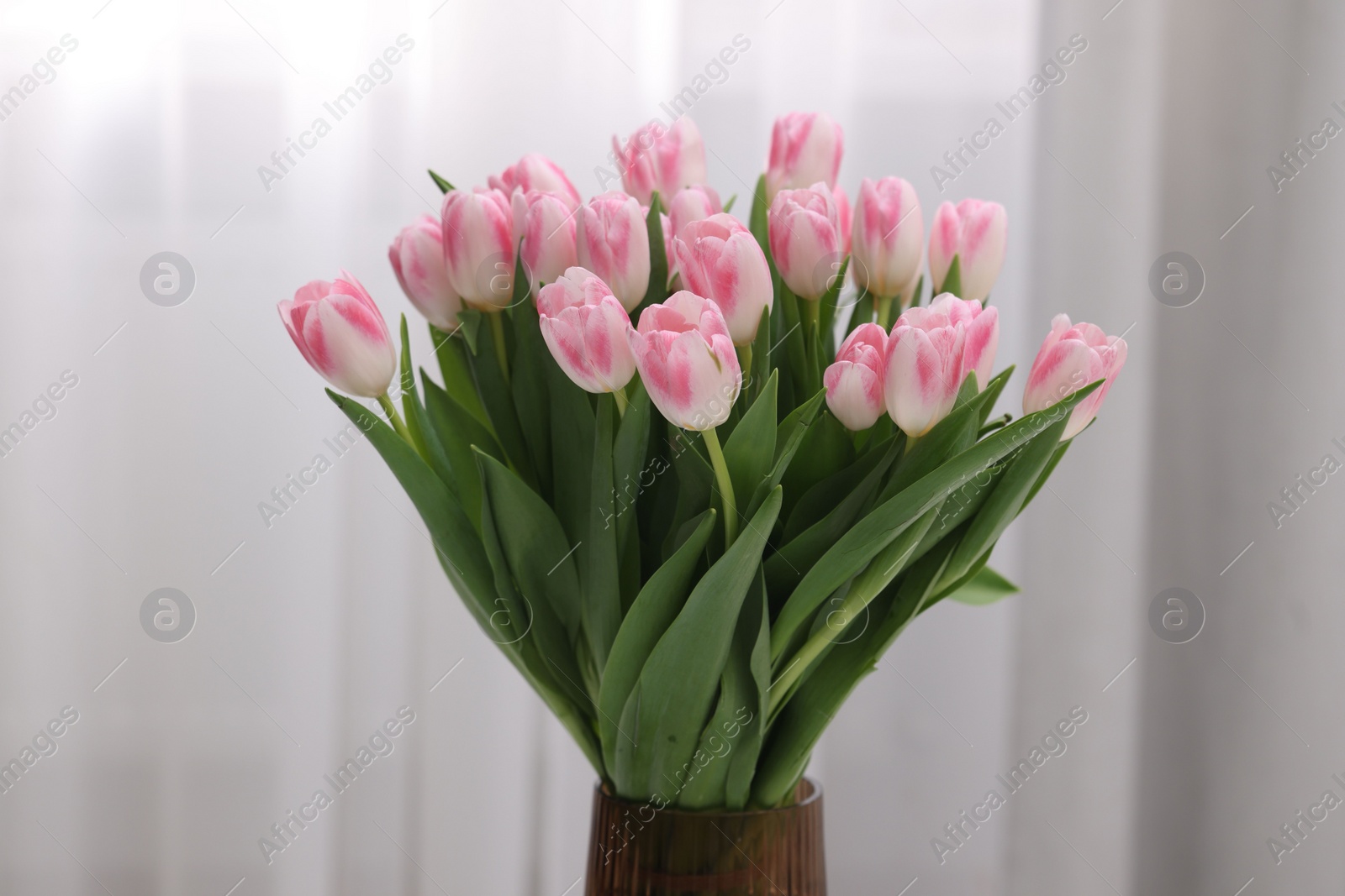 Photo of Beautiful bouquet of fresh pink tulips indoors