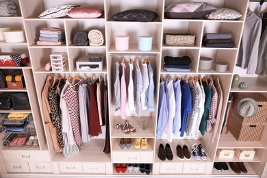 Photo of Large wardrobe with different clothes, home stuff and shoes