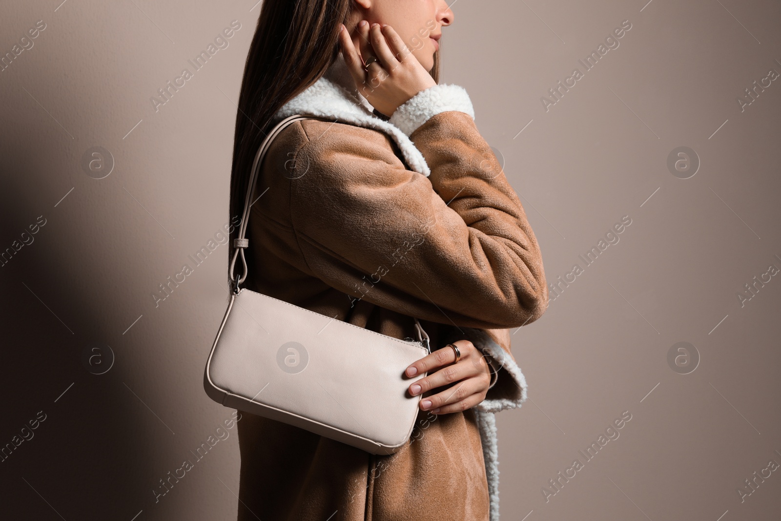 Photo of Fashionable young woman with stylish bag on beige background, closeup
